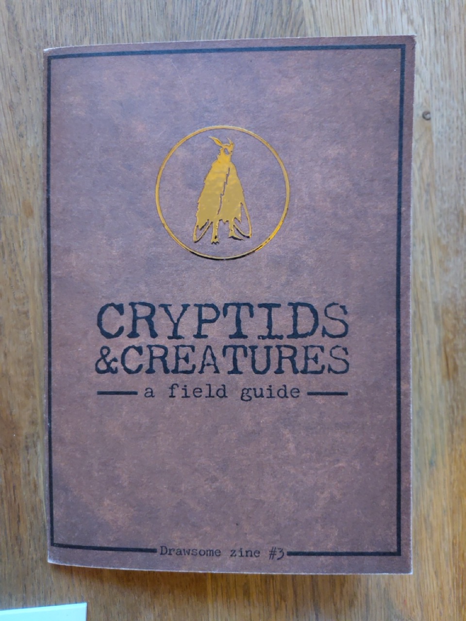 shiny cover of zine about cryptids